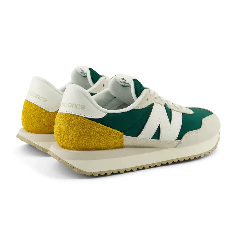 New Balance 237 V1 sneakers in green, white, and yellow suede with retro design, back angle showing heel detail.