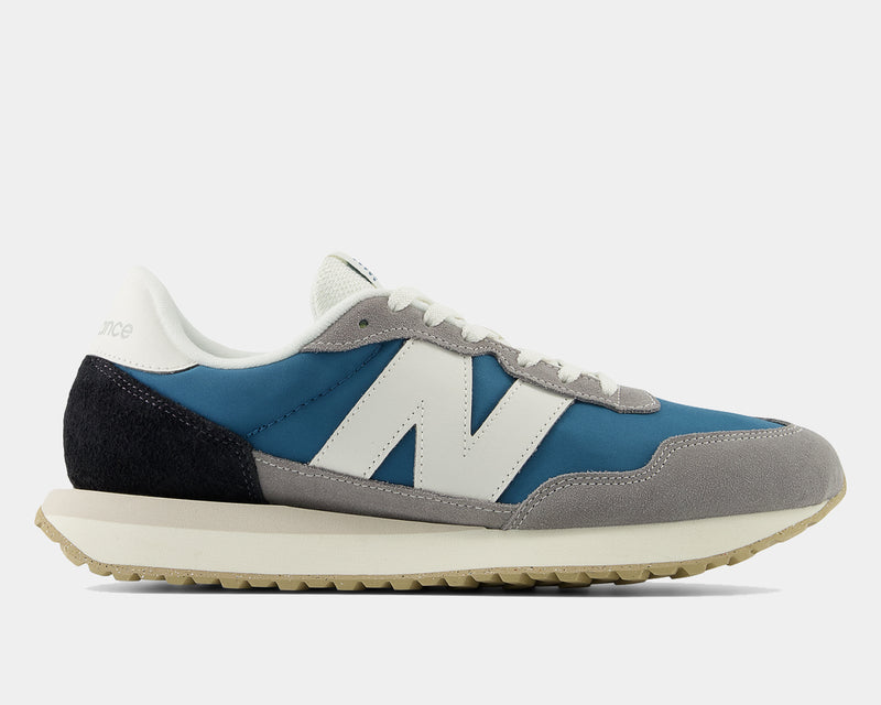 New Balance 237 V1 sneakers in blue, gray, white suede and mesh upper, side profile view showing retro-inspired design.