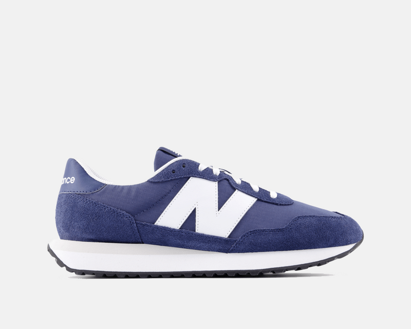 New Balance 237 sneakers in navy blue with white accents, suede and mesh upper, and retro-inspired design, side view.