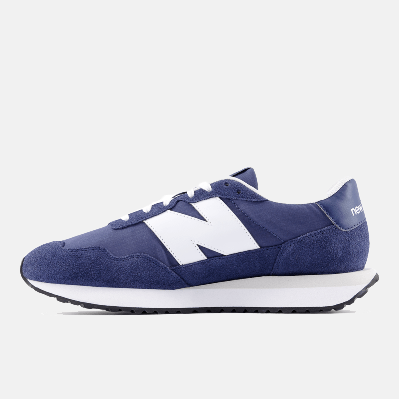 New Balance 237 sneakers in navy with white suede and nylon upper, large side "N" logo, and cushioned midsole, side view.