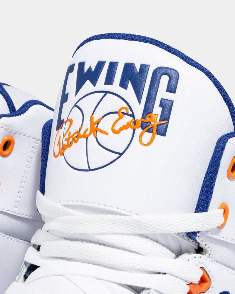 Ewing Athletics 33 HI OG sneakers in white with blue and orange details, featuring signature branding on the tongue, close-up view.