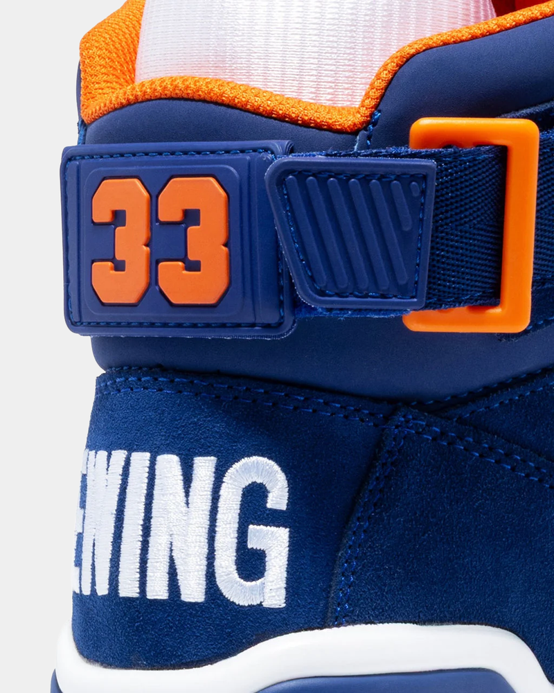 Ewing Athletics 33 HI OG high-top sneakers, close-up of blue suede upper with embroidered branding and orange accents.