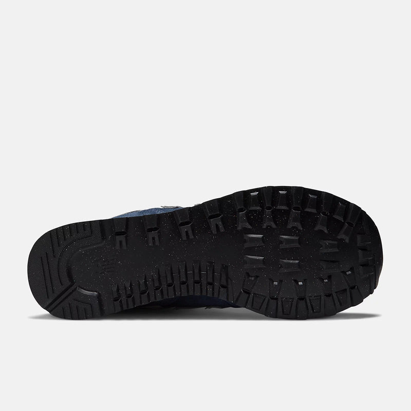 New Balance 574 Core shoes outsole showing durable black rubber tread pattern and flex grooves, bottom view.