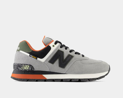 New Balance 574 Rugged sneakers in gray with Cordura fabric, suede overlays, black logo accents, ENCAP midsole, and orange heel detail, side view.