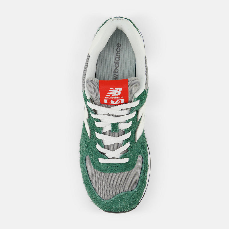 New Balance 574 sneakers top view featuring green textured suede overlays, gray mesh panels, white laces, and red tongue label.