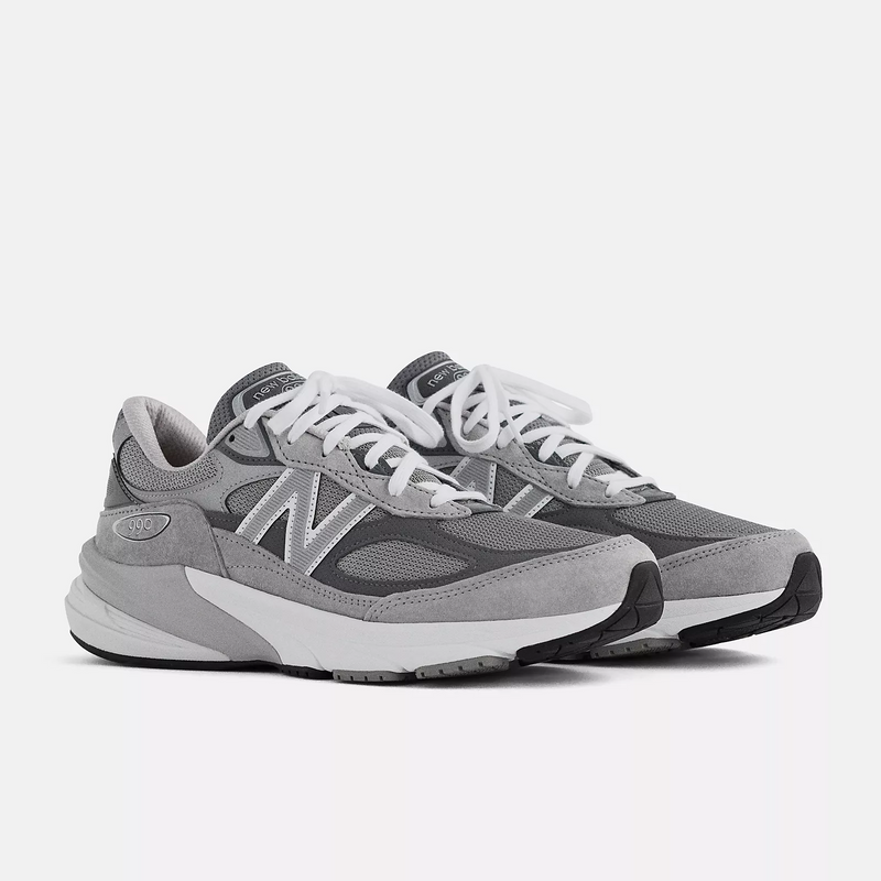 New Balance 990v6 running shoes in gray with suede overlays, mesh panels, and white laces, angled front side view.