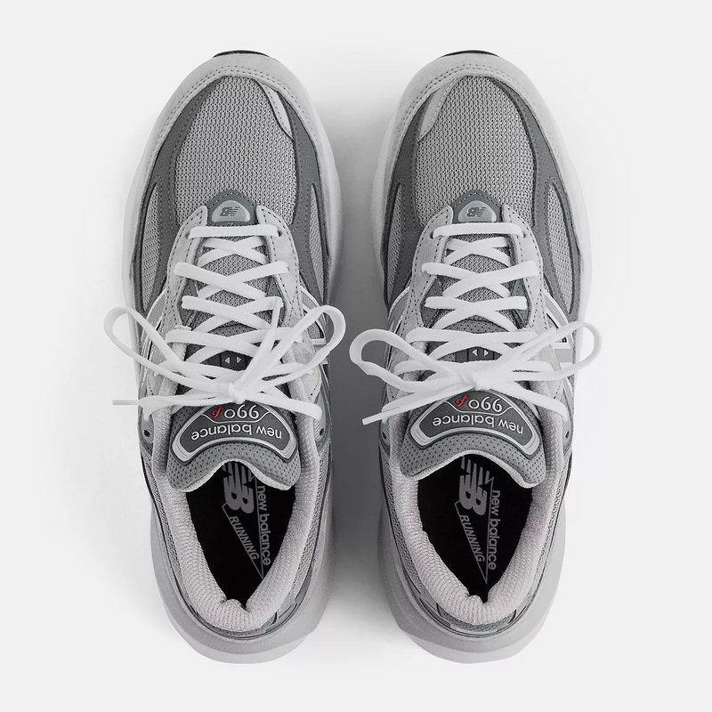 New Balance 990v6 sneakers in gray with mesh upper, white laces, and branded tongue and insole, top view.