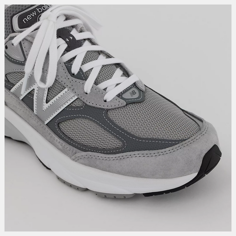 New Balance 990v6 running shoes in gray with mesh upper, suede overlays, white laces, and cushioned midsole, angled front view.