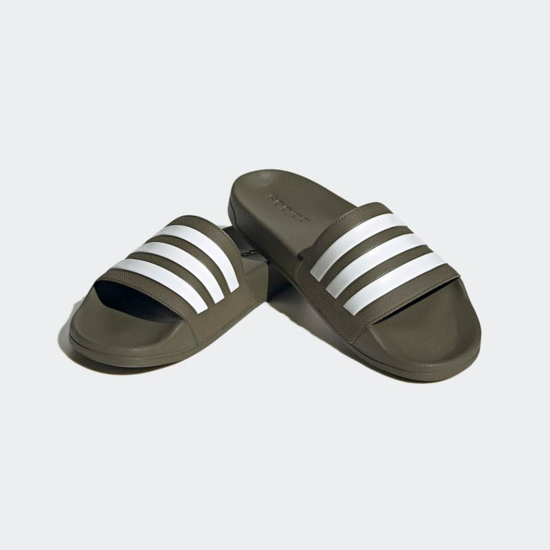Adidas Adilette Comfort slides in olive green with white stripes, featuring a contoured footbed and slip-on design, angled view.