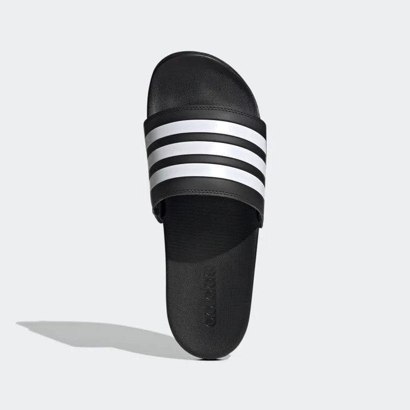 Adidas Adilette Comfort slides in black with iconic white three-stripe strap design, top view showing textured footbed.