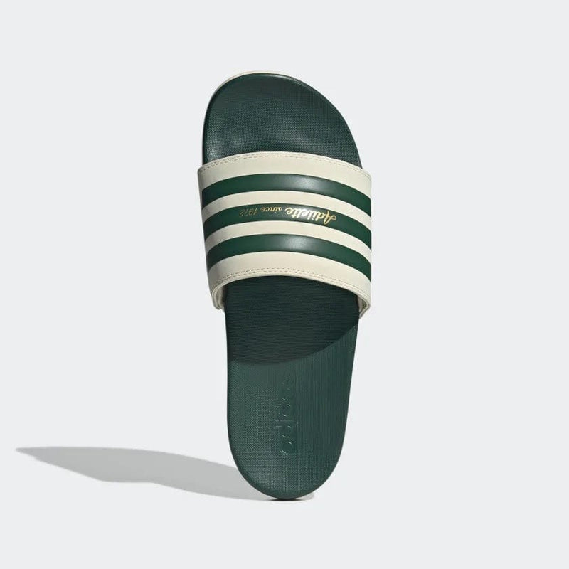 Adidas Adilette Comfort slides in green and cream with striped design and embossed logo, top view.