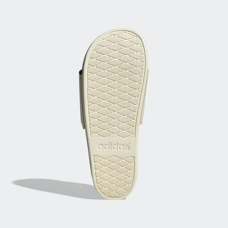 Adidas Adilette Comfort slide sandal beige outsole with textured diamond pattern and branded logo, sole/bottom view