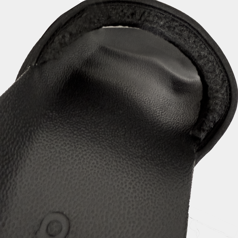 Adidas Adilette NoShower slides in black, close-up view showing textured footbed and soft padded strap detail.