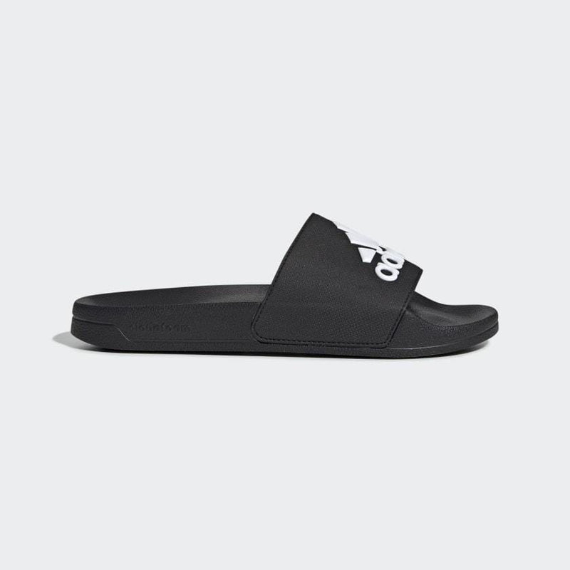 Adidas Adilette Shower Slides in black with a white logo and synthetic strap, side view