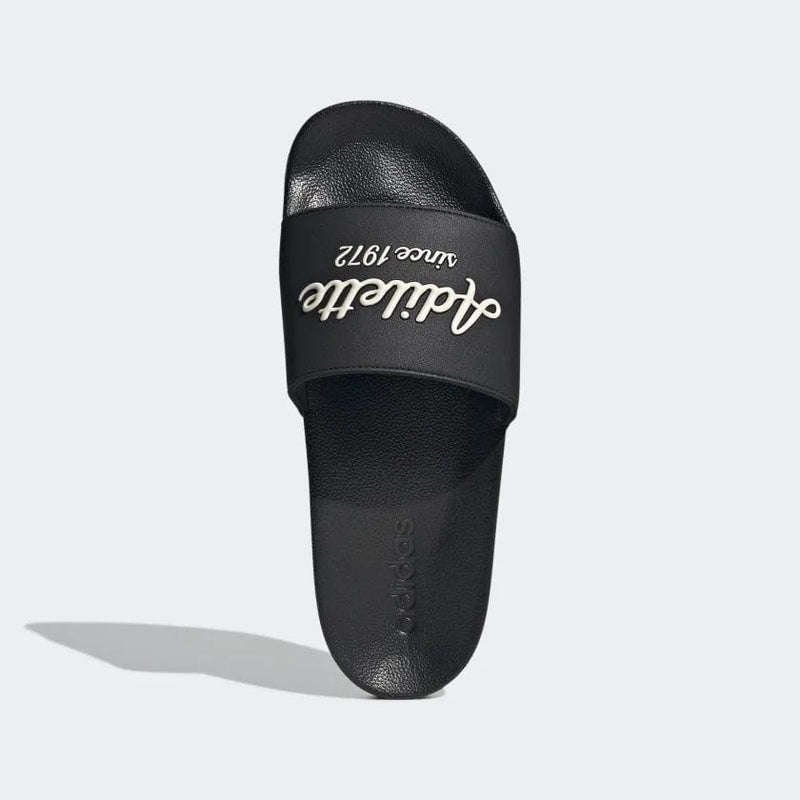 Adidas Adilette Shower Slides black with bold "Adilette since 1972" text on strap, top view.