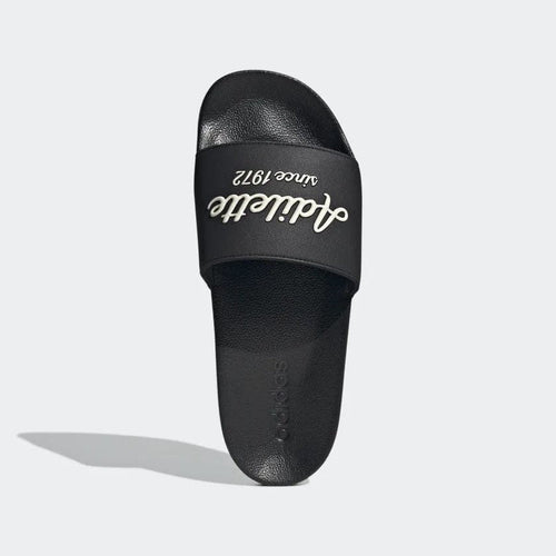 Adidas Adilette Shower Slides black with bold "Adilette since 1972" text on strap, top view.