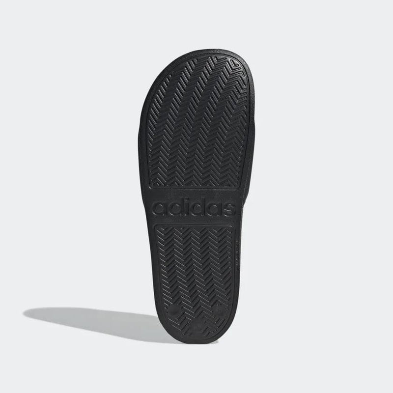 Adidas Adilette Shower Slides sole view in black showing herringbone tread pattern and embossed Adidas logo.