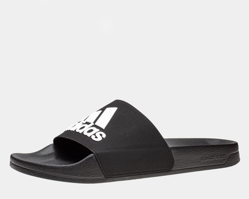 Adidas Adilette Shower Slides in black with white logo, featuring Cloudfoam footbed and textured outsole, side view.