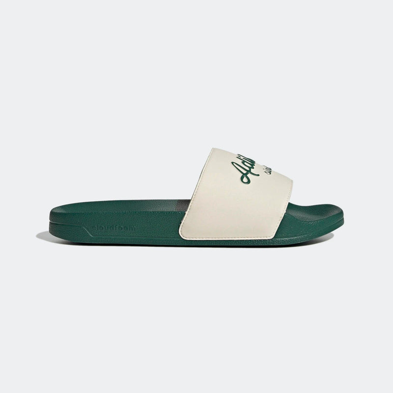 Adidas Adilette Shower Slides in green and white with logo detailing on strap, side view.