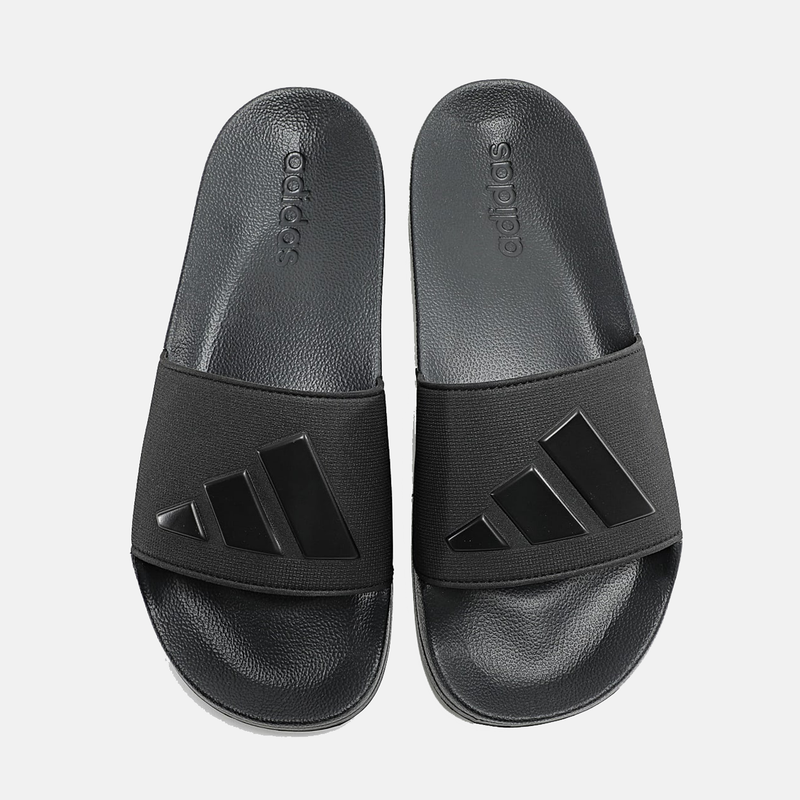 Adidas Adilette Shower Slides in black with textured footbed and Adidas logo on the strap, top view.