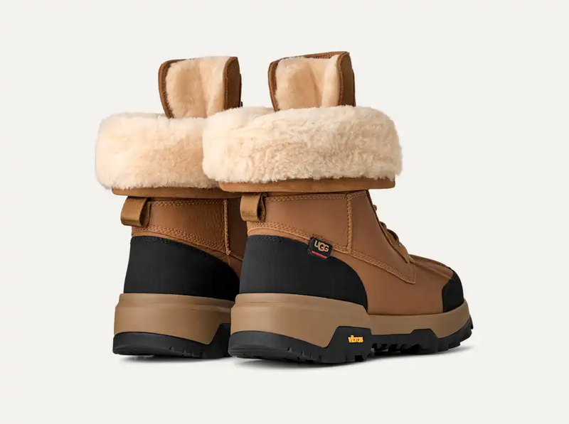 UGG Adirondack Boot XXV winter boots in chestnut brown with black accents, sheepskin lining, and Vibram outsole, back view.