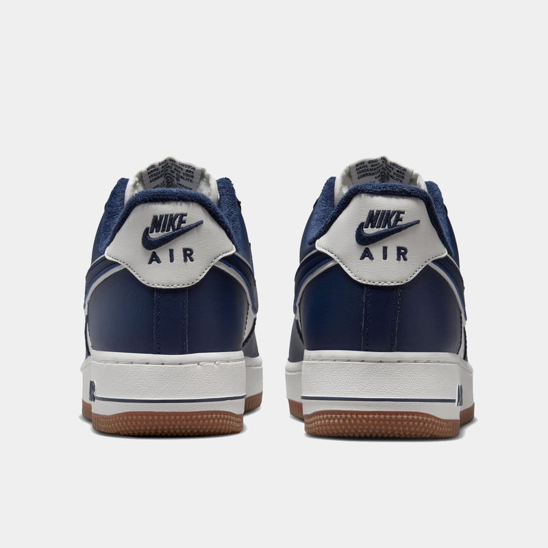 Nike Air Force 1 '07 LV8 sneakers in navy blue and white leather with suede accents, back view showing heel tab and Nike Air branding.