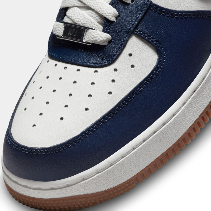 Nike Air Force 1 '07 LV8 sneakers with white perforated leather toe box, navy leather overlays, and gum rubber outsole, close-up view.