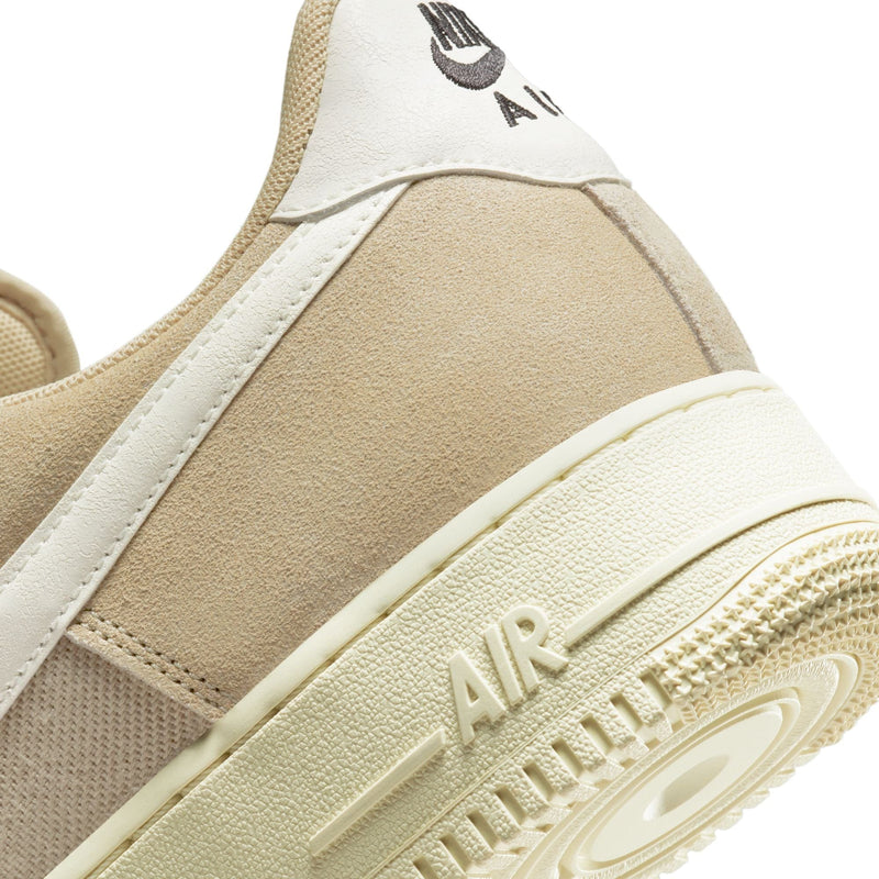 Nike Air Force 1 '07 LV8 sneakers featuring beige suede upper, white leather accents, and embossed "Air" detailing on cream rubber sole, back view.