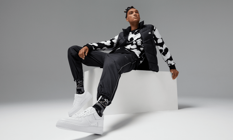 Nike Air Force 1 '07 sneakers in clean white leather design with perforated toe box and signature Swoosh logo, lifestyle setting.