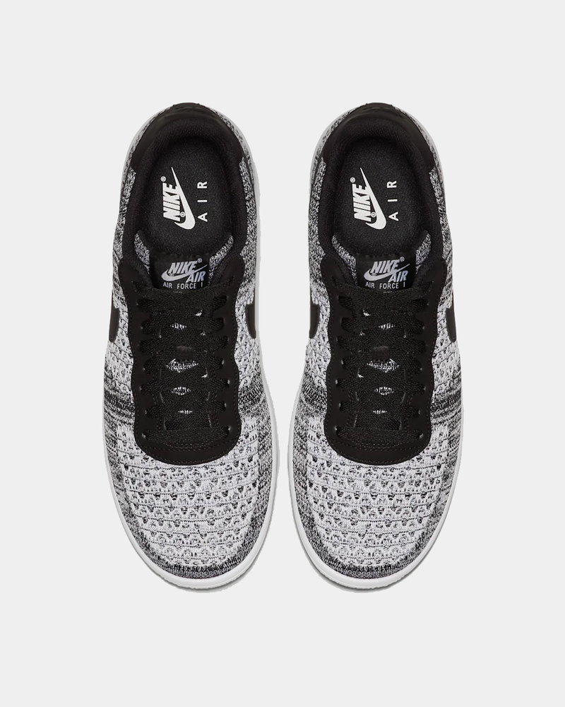 Nike Air Force 1 Flyknit 2.0 sneakers in black and white with breathable Flyknit upper and lace-up design, top view.