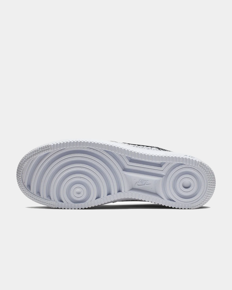 Nike Air Force 1 Flyknit 2.0 sneakers sole in white with circular tread design and embossed branding, bottom view.