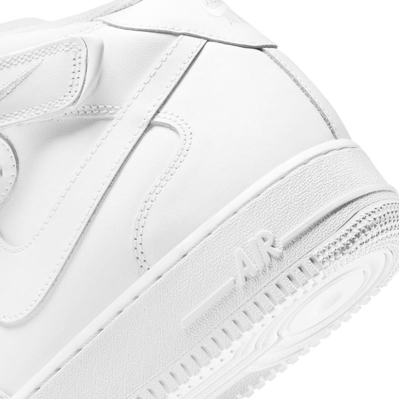 Nike Air Force 1 Mid '07 sneakers in white leather with embossed "AIR" logo and textured outsole, angled close-up view.