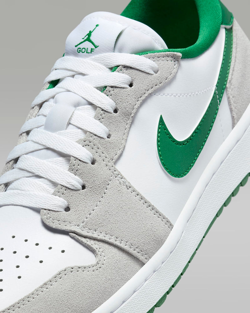 Nike Air Jordan 1 Low G golf shoes with white perforated leather upper, gray suede overlays, and green swoosh, close-up toe box view.