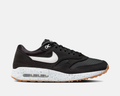 Nike Air Max 1 '86 OG Golf shoes in black with a white Swoosh, speckled midsole, and gum outsole, side view.
