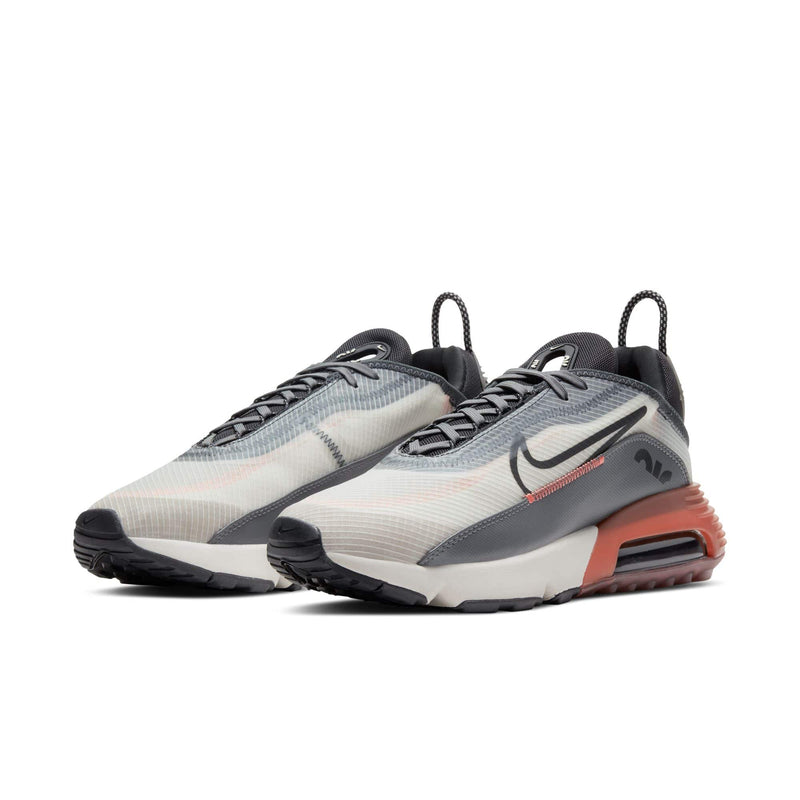 Nike Air Max 2090 shoes with translucent mesh upper, black accents, and orange Air Max unit, front side angle.