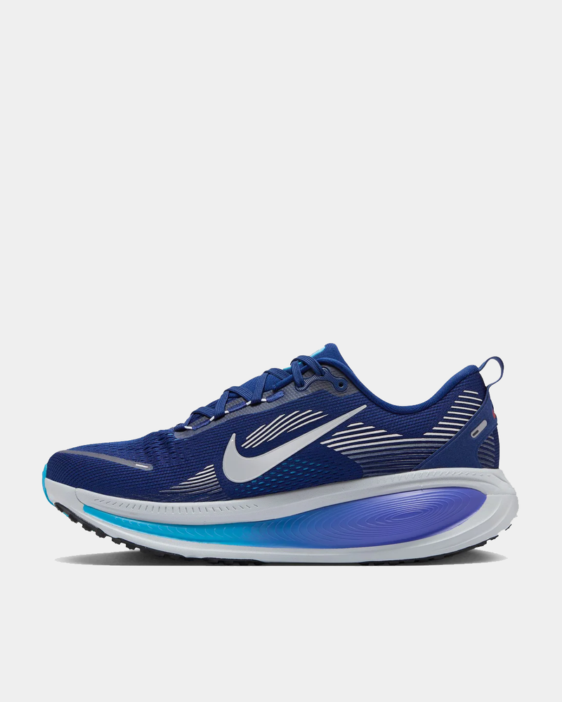 Nike Air Zoom Vomero 18 running shoes in deep blue with white accents, mesh upper, and Zoom Air cushioning, side view.