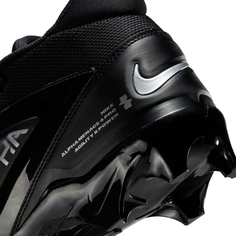 Nike Alpha Menace Elite 4 football cleats in black with textured upper, silver branding, and spiked outsole, side and heel close-up.