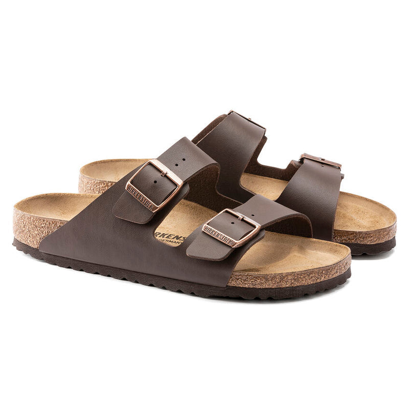 Birkenstock Arizona Birko-Flor® sandals in dark brown with adjustable dual straps, cork footbed, and copper buckles, angled view.