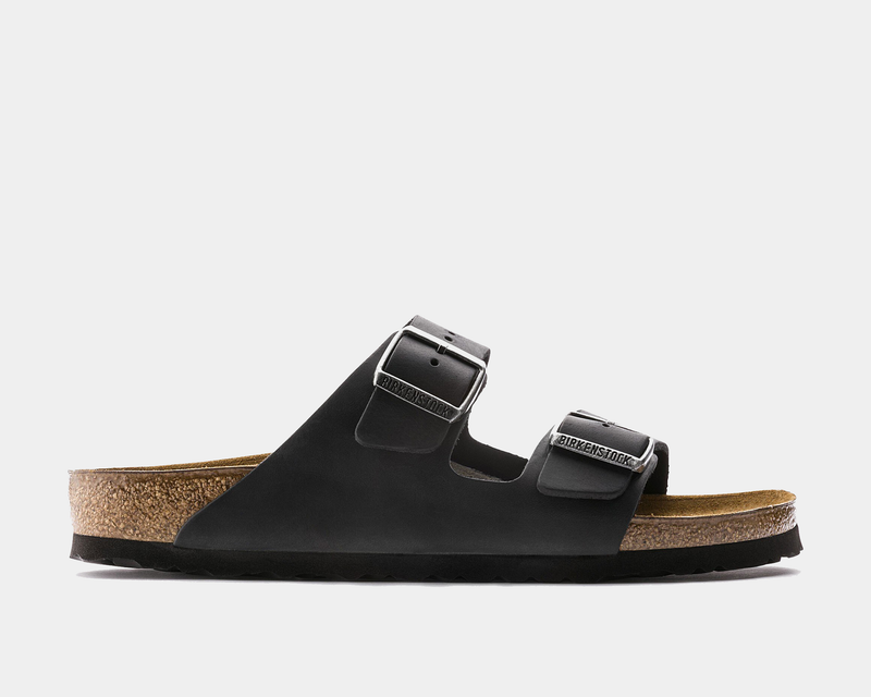 Birkenstock Arizona Oiled Leather sandals in black with adjustable metal buckles and cork footbed, side view.
