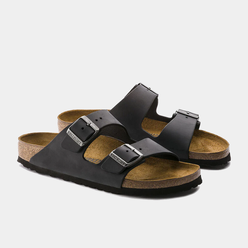 Birkenstock Arizona Oiled Leather sandals in black with dual adjustable buckle straps and cork footbed, angled front view.