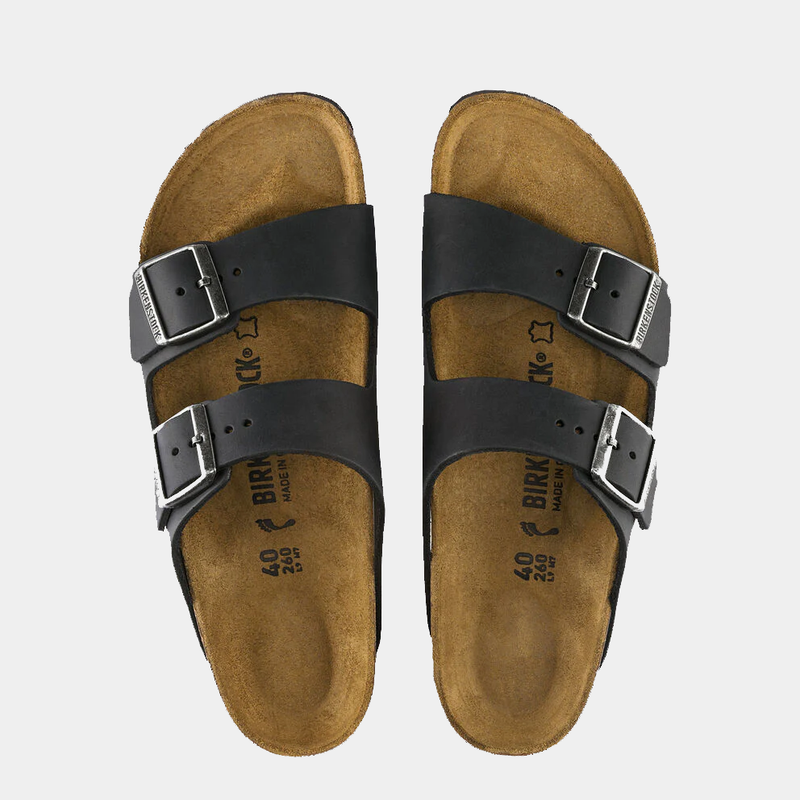Birkenstock Arizona Oiled Leather sandals in black with adjustable buckled straps and contoured cork footbed, top view.