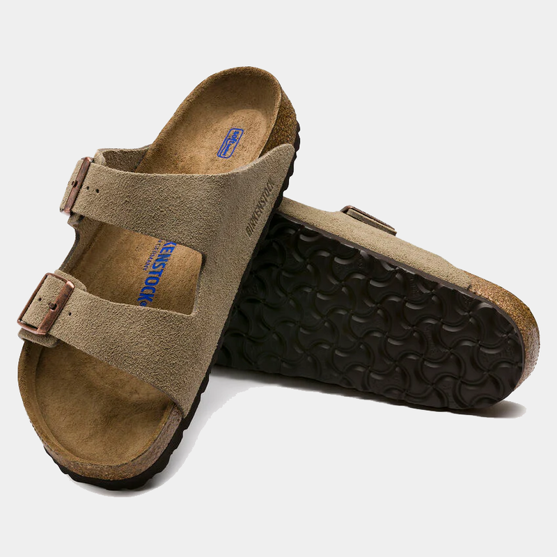 Birkenstock Arizona Soft Footbed Suede sandals in taupe with adjustable straps, cork footbed, and black rubber outsole, angled view.