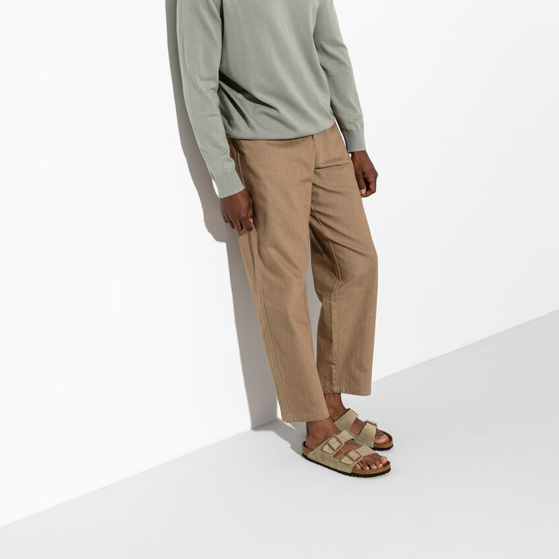 Birkenstock Arizona Soft Footbed Suede sandals in taupe with adjustable straps and cushioned footbed, lifestyle view worn by a man.
