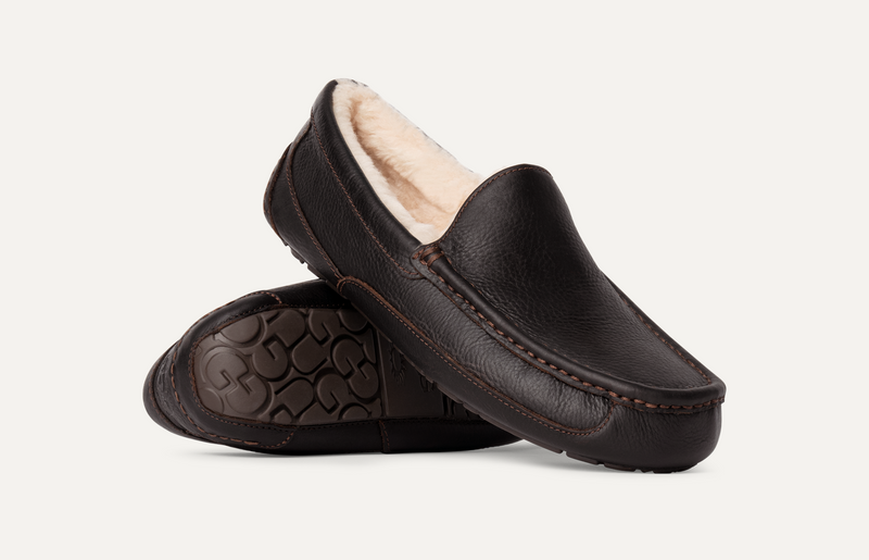 UGG Ascot Leather slippers in dark brown leather with stitched details and plush shearling lining, side and sole view.