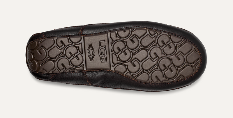 UGG Ascot Leather slippers sole in dark brown leather with embossed UGG logo pattern, bottom view.