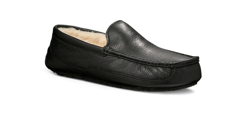 UGG Ascot Leather slippers in black leather with soft shearling lining and moc-toe stitching, side view.