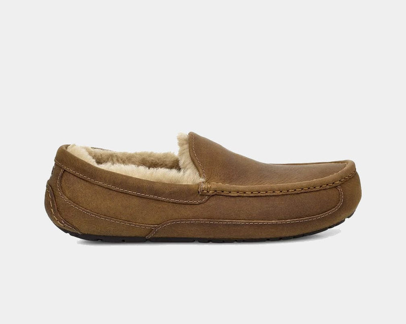 UGG Ascot Matte Leather slippers in brown matte leather with stitched detailing and plush shearling lining, side view.