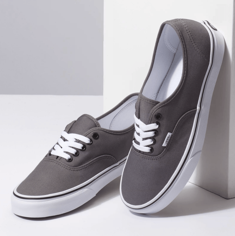 Vans Authentic sneakers in dark gray canvas with white lace-up closure and rubber outsole, angled front view.