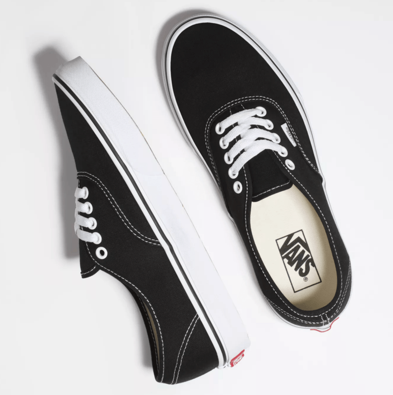 Vans Authentic sneakers in black canvas with white stitching, laces, and rubber outsole, top angled view.