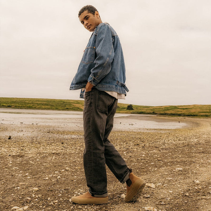 SeaVees Ballard Boot in tan suede with elastic side panels and rugged sole, worn outdoors near a lakeside.
